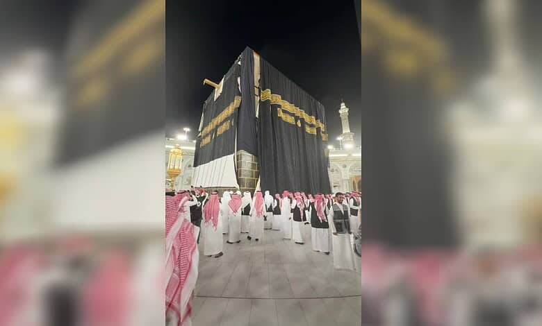 The Kaaba in Makkah draped with a newly installed Kiswah marking the Islamic New Year 1448 AH, as workers and worshippers gather in the Grand Mosque at night.