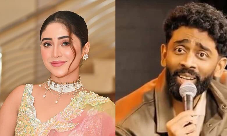 Elegant woman in traditional attire smiling, and a man with a beard speaking into a microphone at an even.