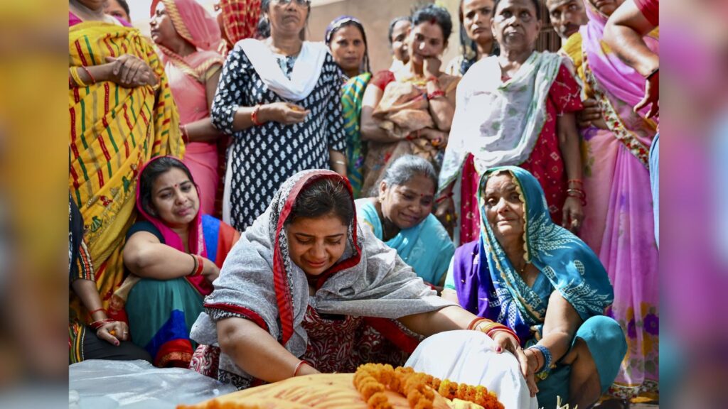 Women participating in a traditional Indian ceremony, dressed in colorful sarees and engaged in a ritual.
