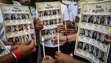 People holding posters of martyrs during a memorial event in India.