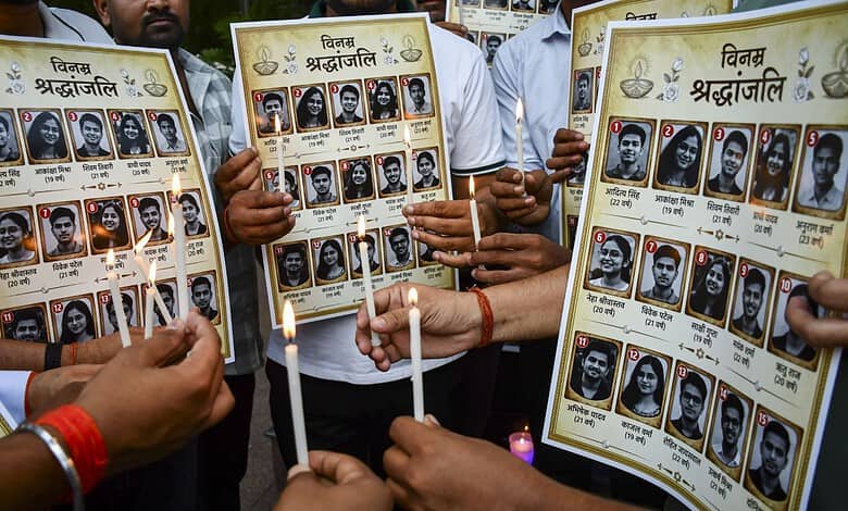 People holding posters of martyrs during a memorial event in India.