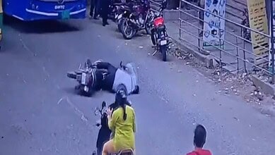 A man falls on road after being hit by a tree trunk