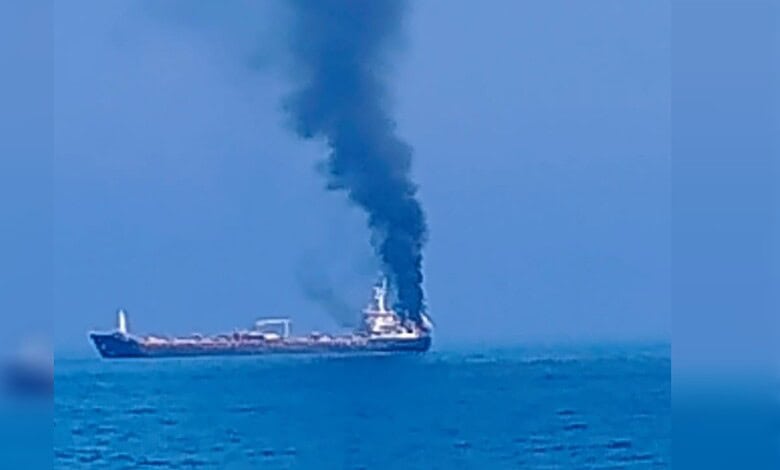 Oil tanker releasing thick black smoke into the sky while sailing on the ocean.