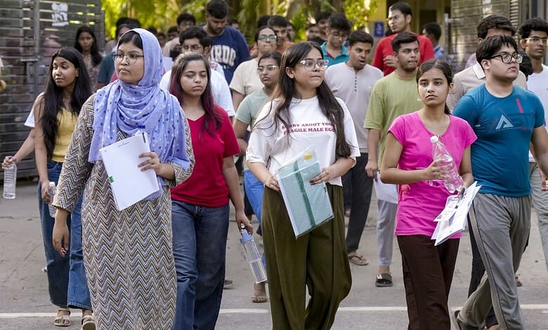 Students waiting in line for NEET retest after paper leak row, holding admit cards and documents.