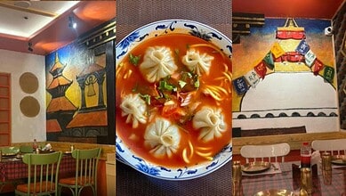 Interior of a Nepali restaurant with colourful wall art and dining tables.