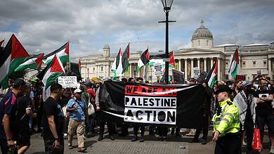 Protesters in London holding a Palestine Action banner during a demonstration for Palestinian rights.
