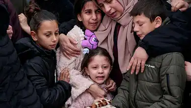 Group of Palestinian children mourning, emotional scene in West Bank.