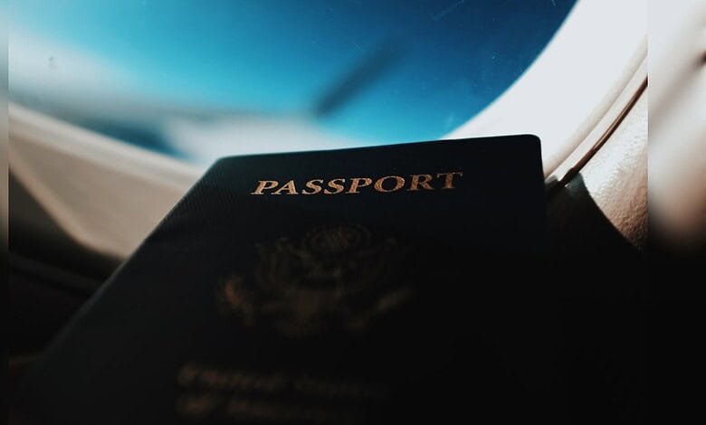 Passport resting on a car dashboard with a view of the night sky through the windshield.