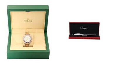 Luxury Rolex watch in green box and Cartier pen in black box with red trim.
