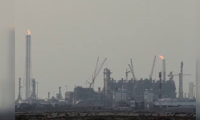 Industrial gas plant with smoke and flames, cranes, and industrial structures in Qatar.
