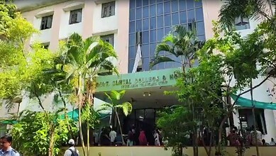 Students entering Osmania Medical College amid lush greenery and tall trees.