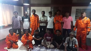 Group of prisoners and officials posing together in detention centre.