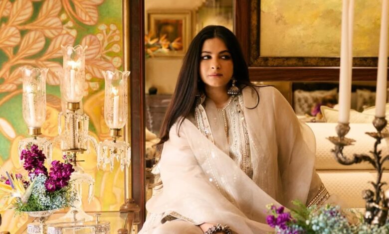Rhea Kapoor wearing elegant traditional attire with floral decor in the background.
