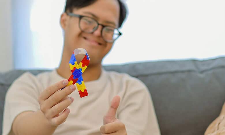 Happy person holding a colourful puzzle piece, smiling at home.