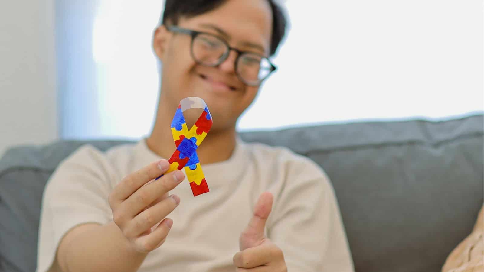 Happy person holding a colourful puzzle piece, smiling at home.