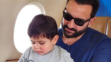 Saif Ali Khan with his son Jeh on an airplane, both looking down.