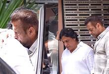 A woman and two men inspecting documents outside The Siasat Daily office in India.
