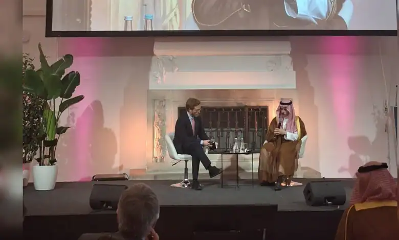 Saudi business leader in traditional attire being interviewed on stage at a conference.
