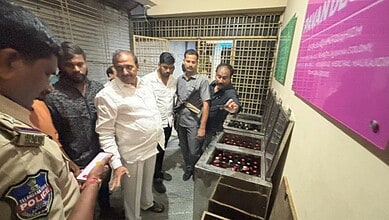 Group of men, including police officer, examining electronic devices at a tech exhibition.