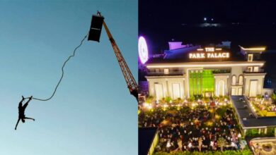 A person hanging from a crane during a skydiving stunt at night.