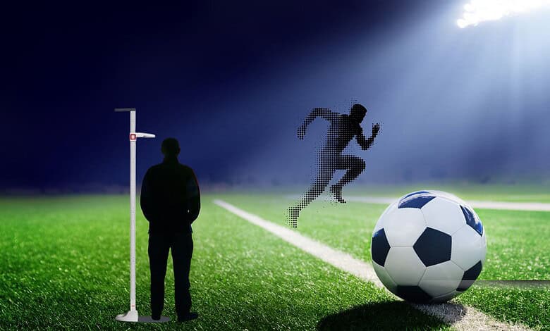 Silhouette of a soccer player jumping to score a goal during a match at night.