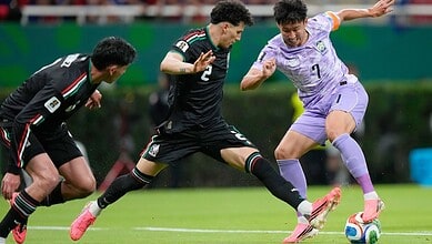 South Korean and Mexican football players competing for the ball during a World Cup match.
