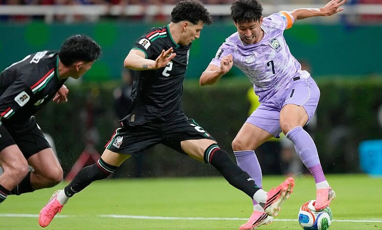 South Korean and Mexican football players competing for the ball during a World Cup match.