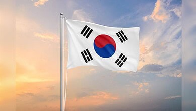 South Korean national flag flying against a cloudy sky.
