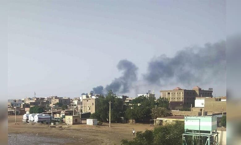 Urban skyline with smoke rising from distant buildings in Hyderabad, India.