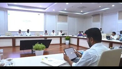 Members of the Telangana cabinet participate in a paperless meeting in a modern conference room.