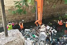 GHMC workers clean up trash from Darussalam nala