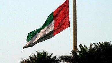 Flag of the United Arab Emirates waving in the wind, with green, white, black, and red colours.