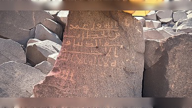Ancient Arabic inscription carved on a stone slab at an archaeological site in Al-Mahd Governorate, Madinah region.