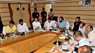 Team of professionals engaged in a meeting around a large conference table at The Siasat Daily office.
