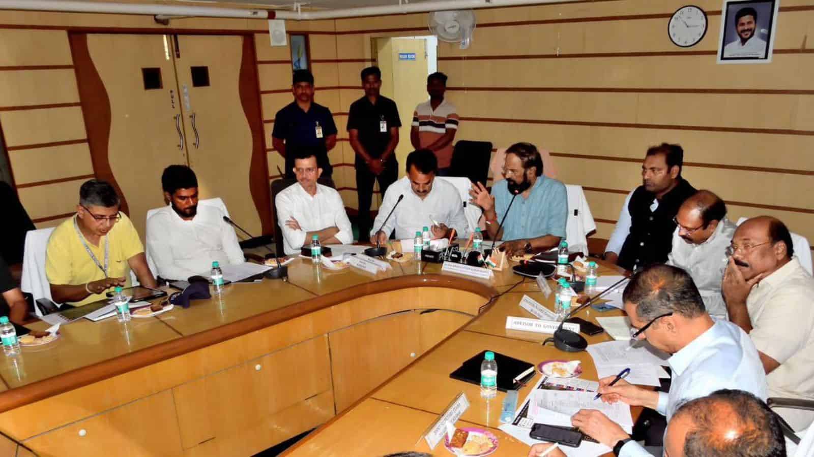Team of professionals engaged in a meeting around a large conference table at The Siasat Daily office.
