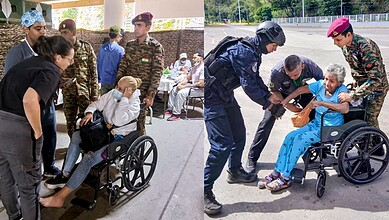 Venezuelan officials and Indian personnel assist elderly in wheelchairs during earthquake relief efforts.