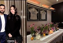 A woman and a man in formal attire standing in front of a decorated table with flowers and framed jerseys.