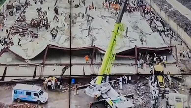 Rescue operation at Kolkata warehouse collapse site with crane and emergency personnel.