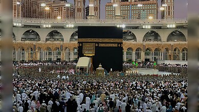A large crowd of worshippers gathered around the Holy Kaaba at Grand Mosque during prayer time.