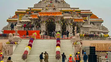 Construction of Ram Mandir with workers and visitors present at the site.