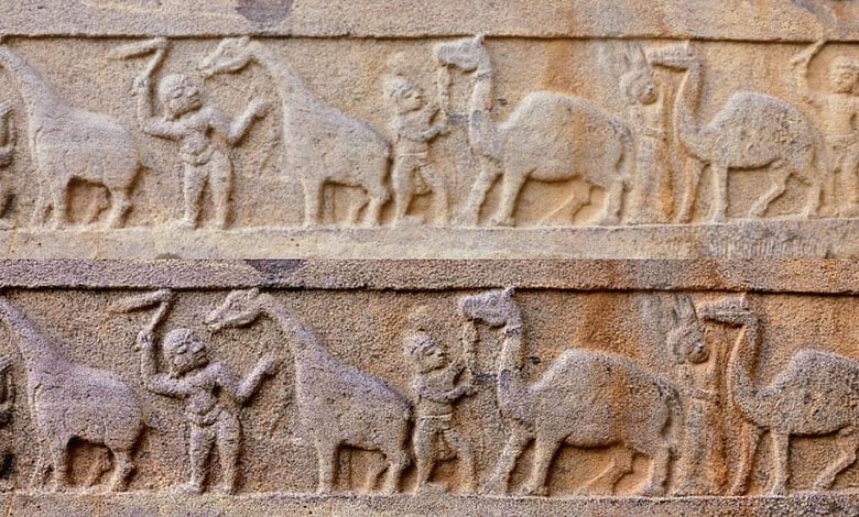 The image shows a panel at Srisailam temple which depicts camels and giraffes with their attendants.