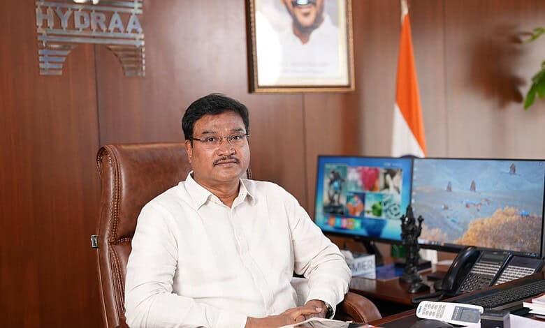 Official portrait of a man in a white shirt sitting at a desk in an office.