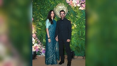 Aamir Khan and Gauri Khan at their wedding celebration, standing in front of a floral backdrop.