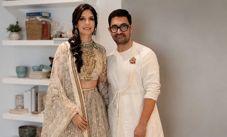 A woman and a man in traditional Indian attire posing indoors.
