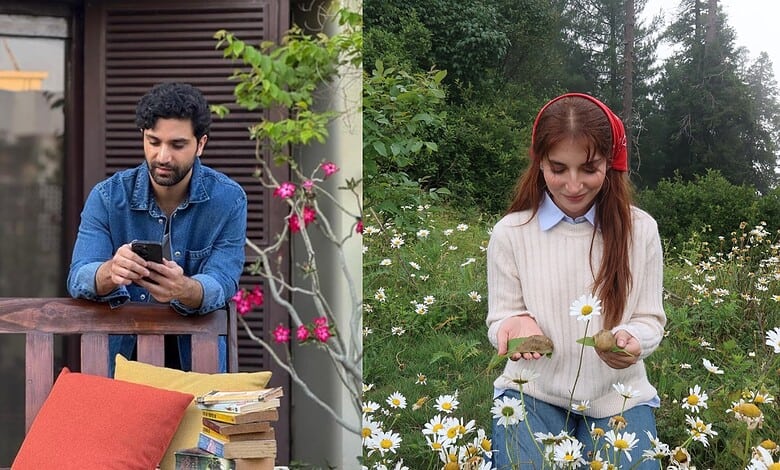 Young man and woman enjoying outdoor time, woman holding daisies, man using smartphone.