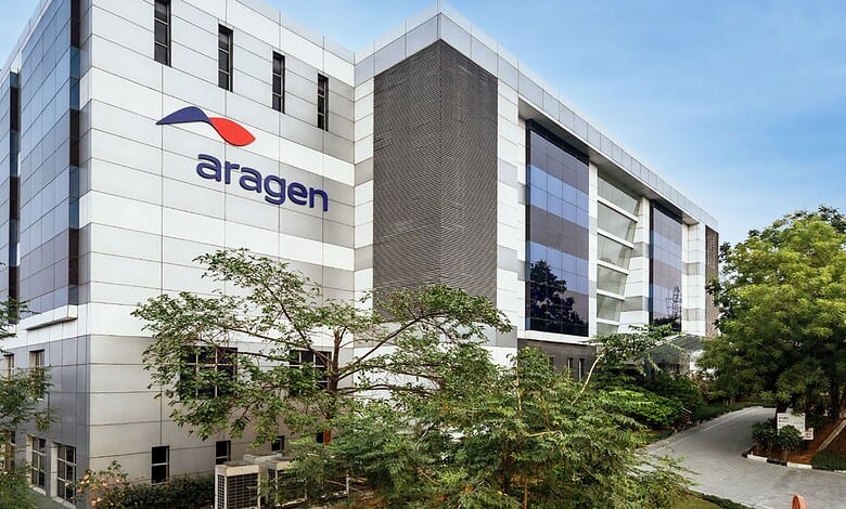 Modern Aragen biotech building with glass windows and logo, surrounded by greenery in an urban setting.