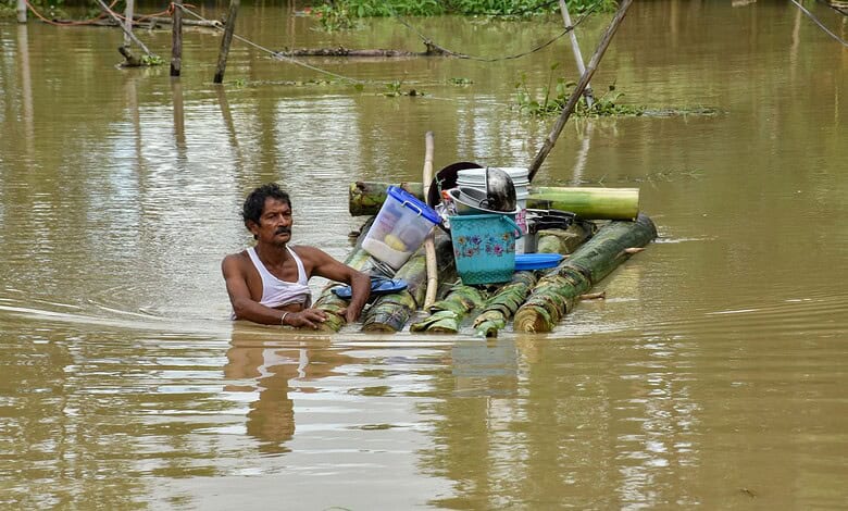 Man on makeshift raft in floodwaters with belongings during a flood rescue.