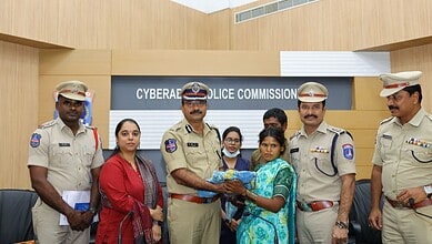 Police officers and a woman holding a baby at Cyberabad Police Commission office.