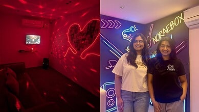Two women smiling at a neon-lit Korean-themed hangout in Sainikpuri, Hyderabad.