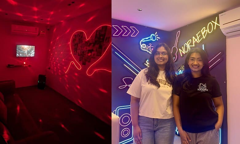 Two women smiling at a neon-lit Korean-themed hangout in Sainikpuri, Hyderabad.